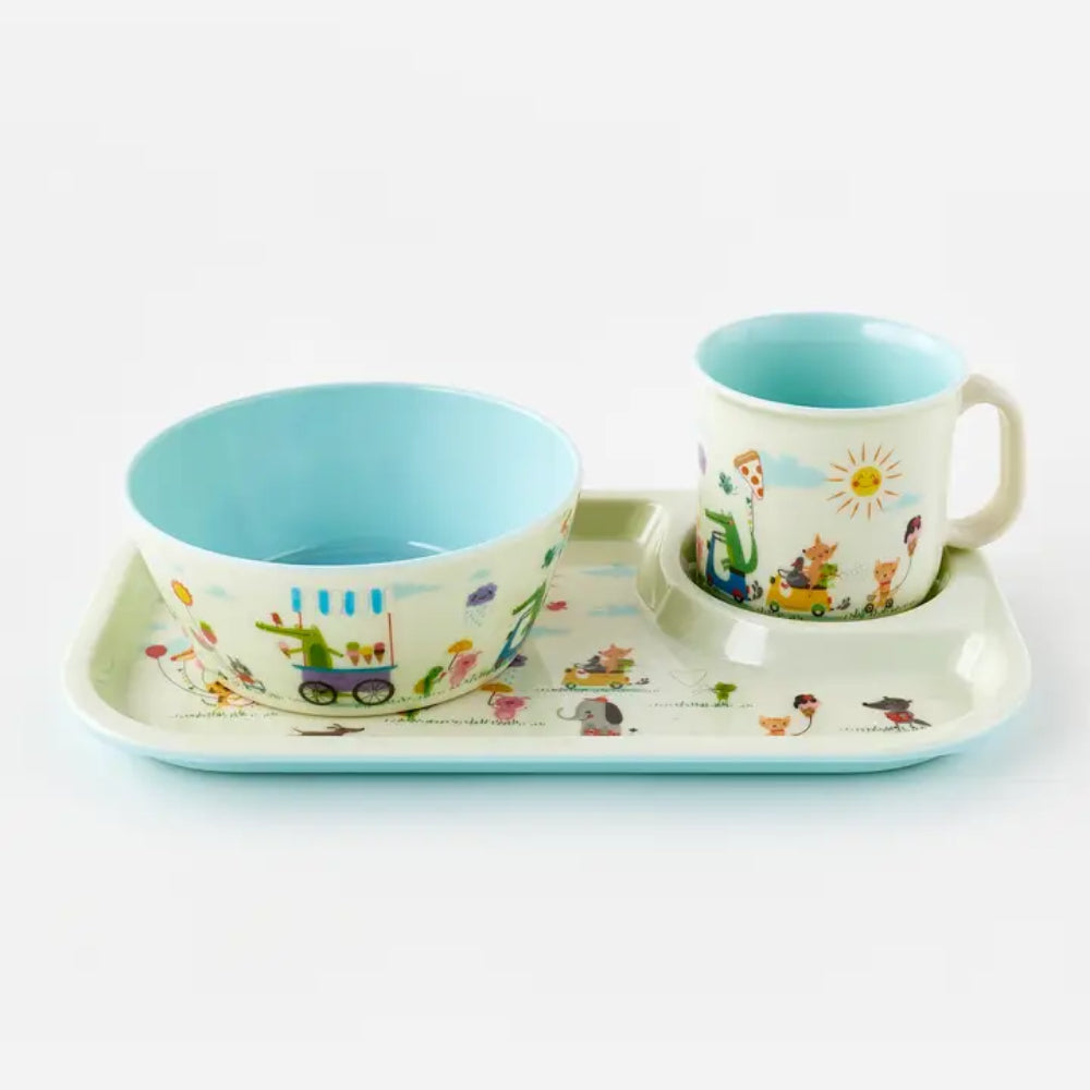 A children's dinnerware set featuring a light blue and white ceramic bowl, matching mug, and a rectangular tray with a colorful animal-themed print, photographed on a clean white background.