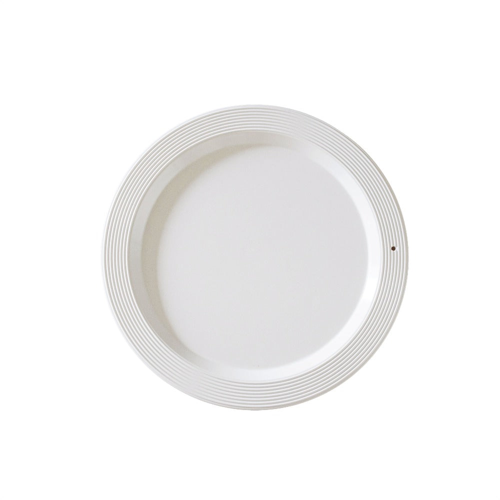 White ceramic plate with decorative rim on a white background