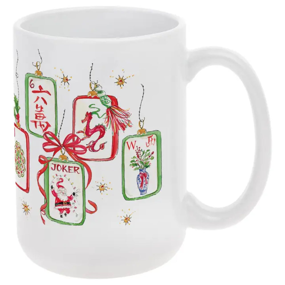 A white ceramic mug decorated with four hanging Christmas ornament illustrations in red, green, and gold, including a dragon, Santa Claus, a flower vase, and the word 'JOKER'.