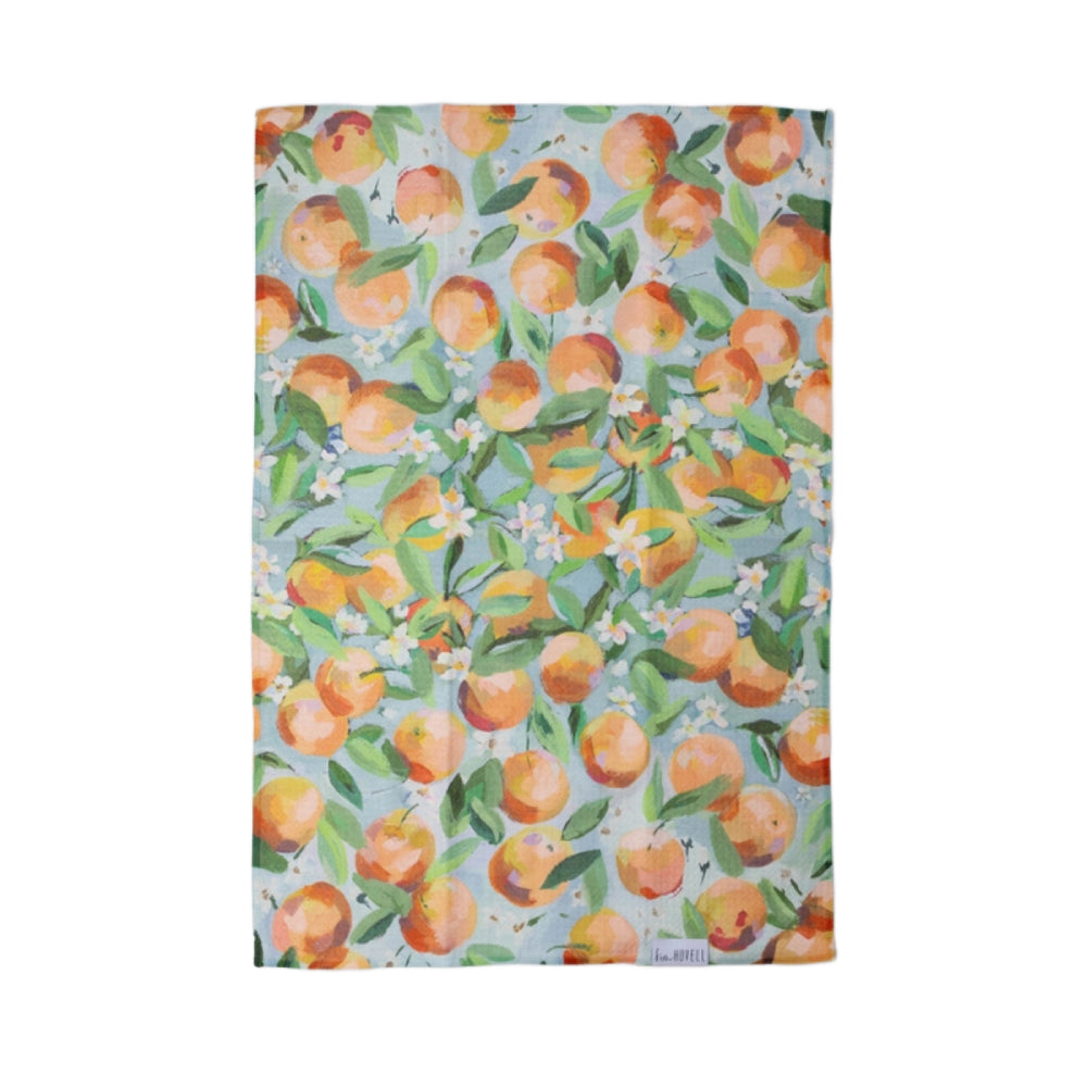 Blue Tea Towel with a pattern of oranges, leaves, and flowers on a white background.