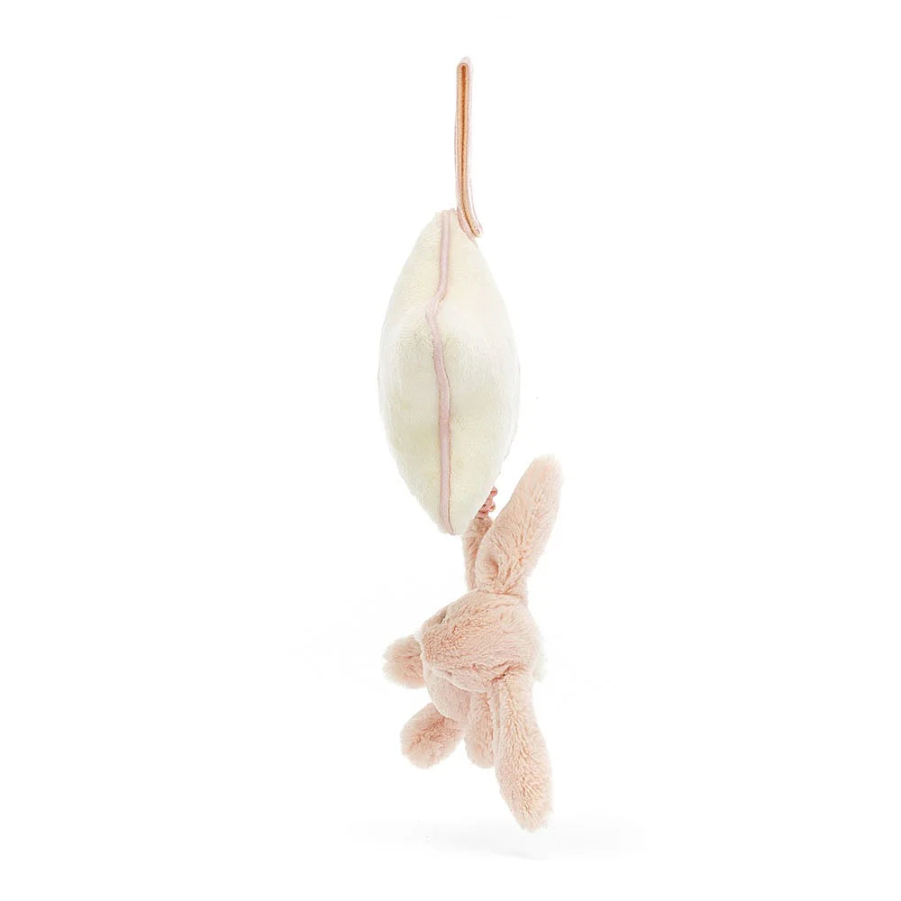 The side of a white star-shaped plush toy with a pink bunny at the on a string bottom on a white background.