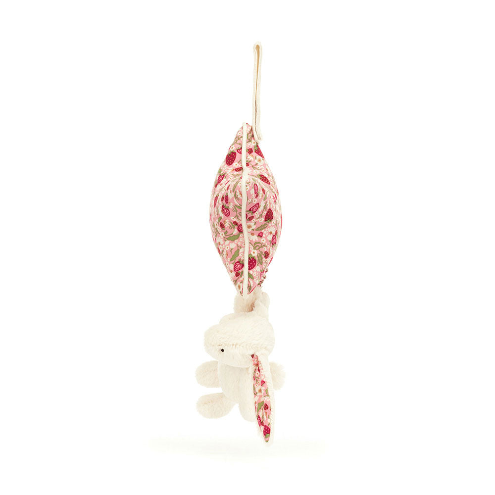 A side phot of a star-shaped fabric rattle with a pink floral pattern and white bunny on a white background.