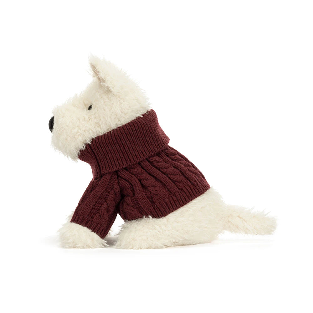A stuffed plush dog in a red jumper sweater outfit on a white background. 