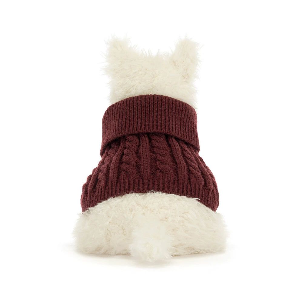 A stuffed plush dog in a red jumper sweater outfit on a white background. 