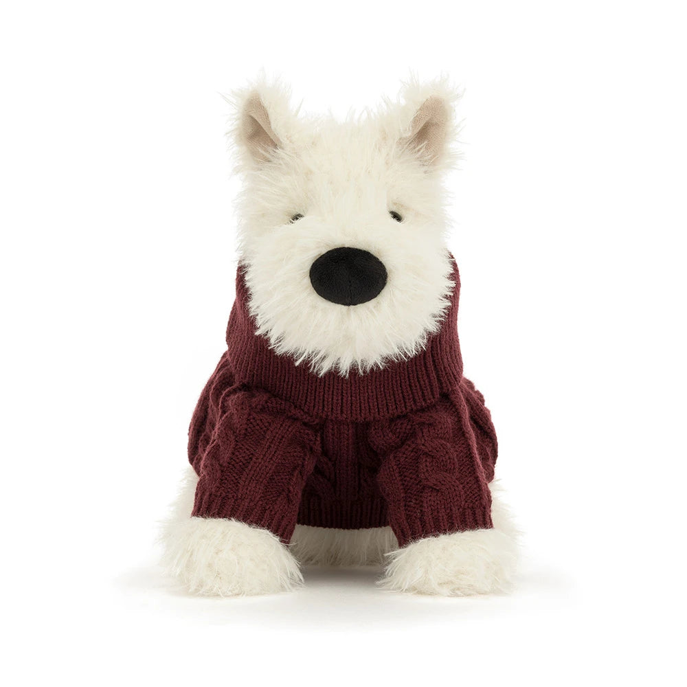 A stuffed plush dog in a red jumper sweater outfit on a white background. 