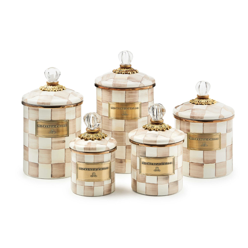 Different sized decorative jars with a mocha checkered pattern and gold accents on a white backround. 