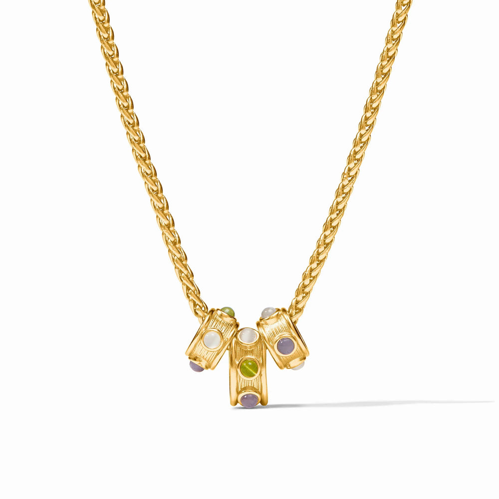 A gold chain necklace with a pendant featuring three small cylindrical gold charms set with white, green, and purple gemstones, shown on a clean white background.
