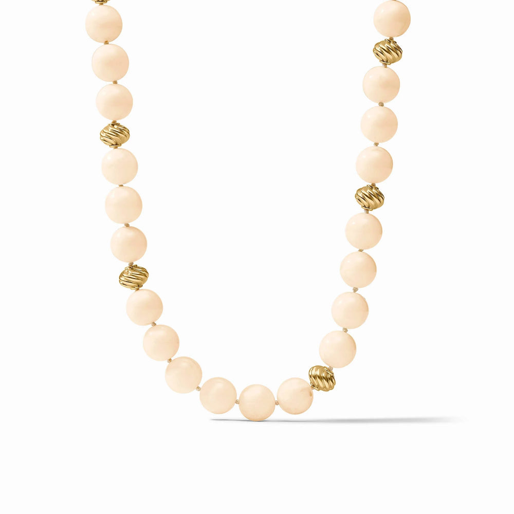 A beaded necklace featuring matte cream-colored round beads and small textured gold spacer beads, displayed on a clean white background.