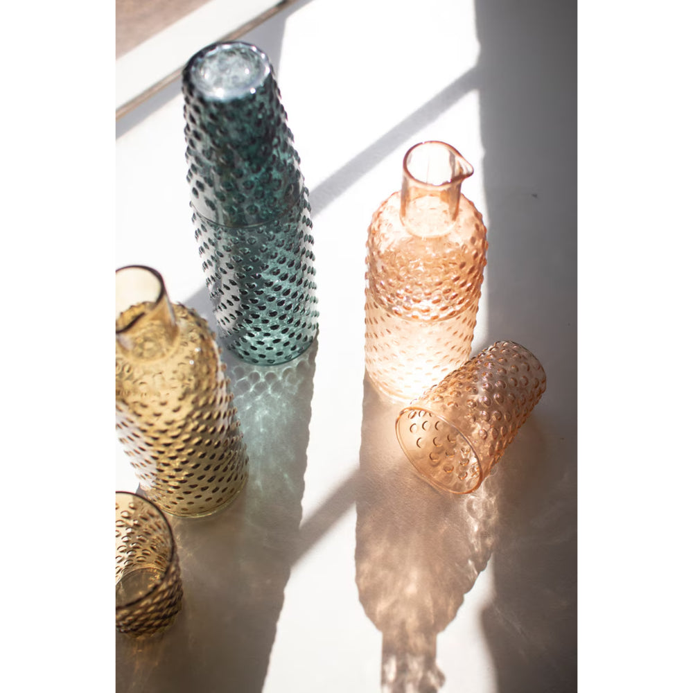 Set of textured glass bottles on a white surface with soft shadows