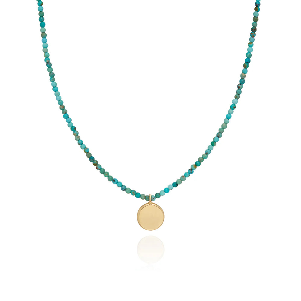 Greenish blue beaded necklace with gold tone round disc charm 