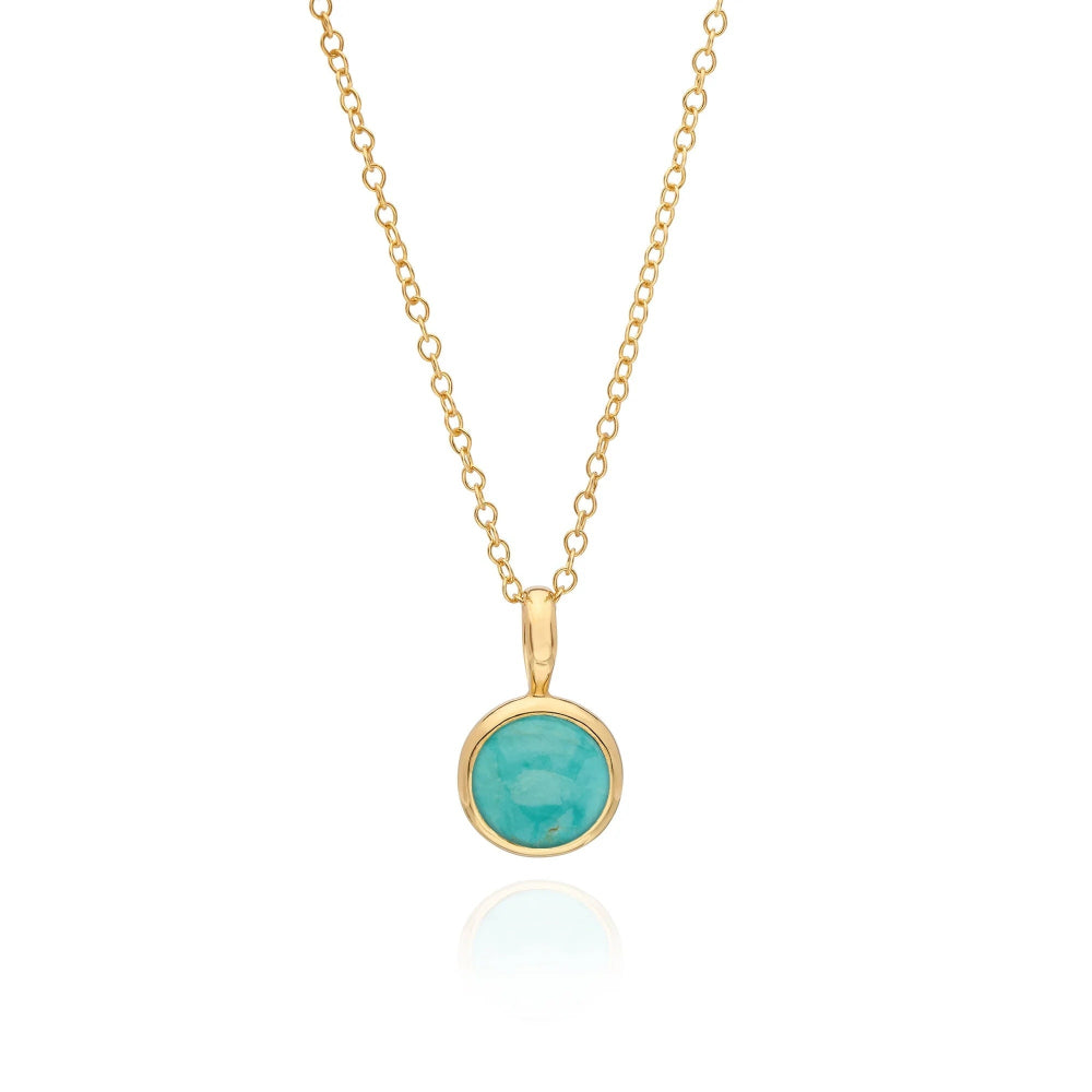 A gold chain necklace with a round bezel-set turquoise pendant 