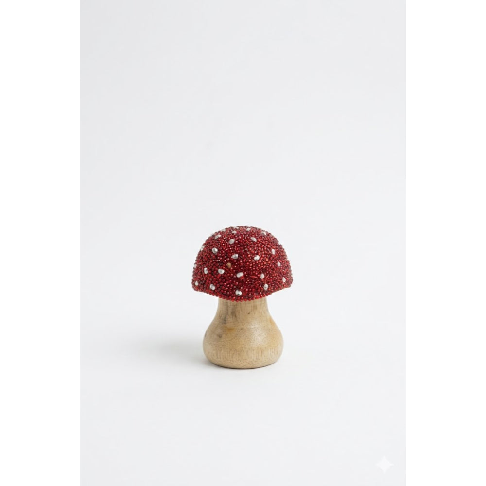 Decorative mushroom with red cap and wooden base on a white background