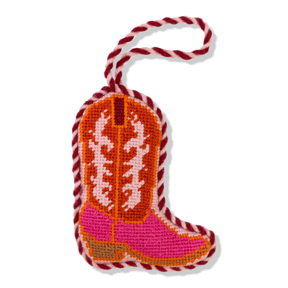 Pink cowboy boot ornament with orange and white pattern on a white background.