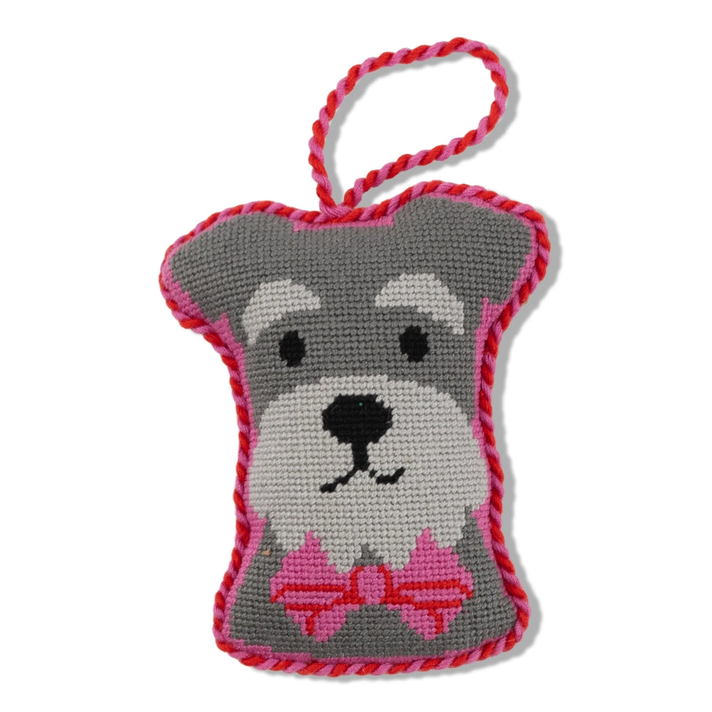 Grey dog-shaped knitted toy with a pink bow on a white background.