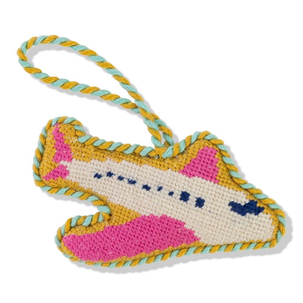 Pink airplane-shaped keychain with gold accents on a white background.