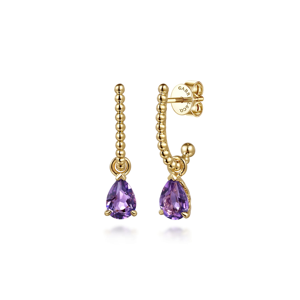 Gold earrings with purple gemstones on a white background