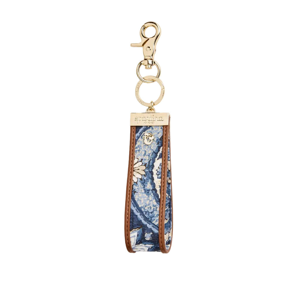 A long fabric keychain strap featuring a blue and white floral pattern with brown leather trim and gold-tone hardware.