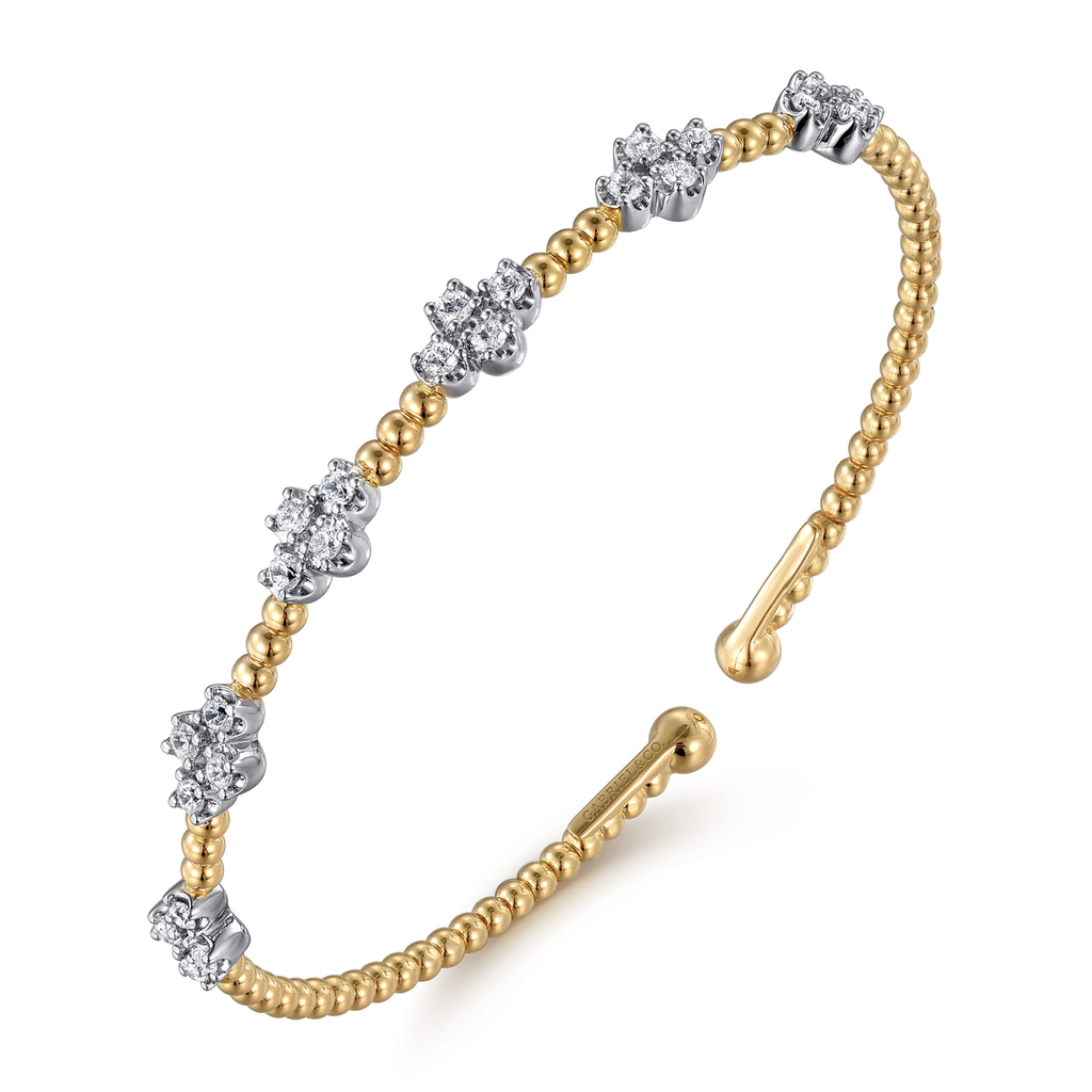 gold beaded bangle bracelet with clear stones on white background