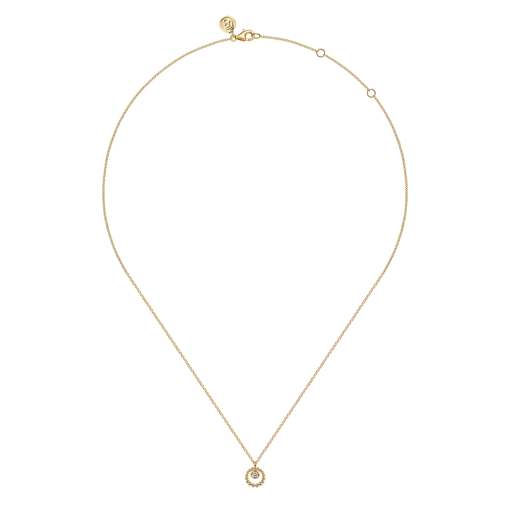 A delicate gold chain necklace with a small circular gold pendant, displayed on a clean white background.