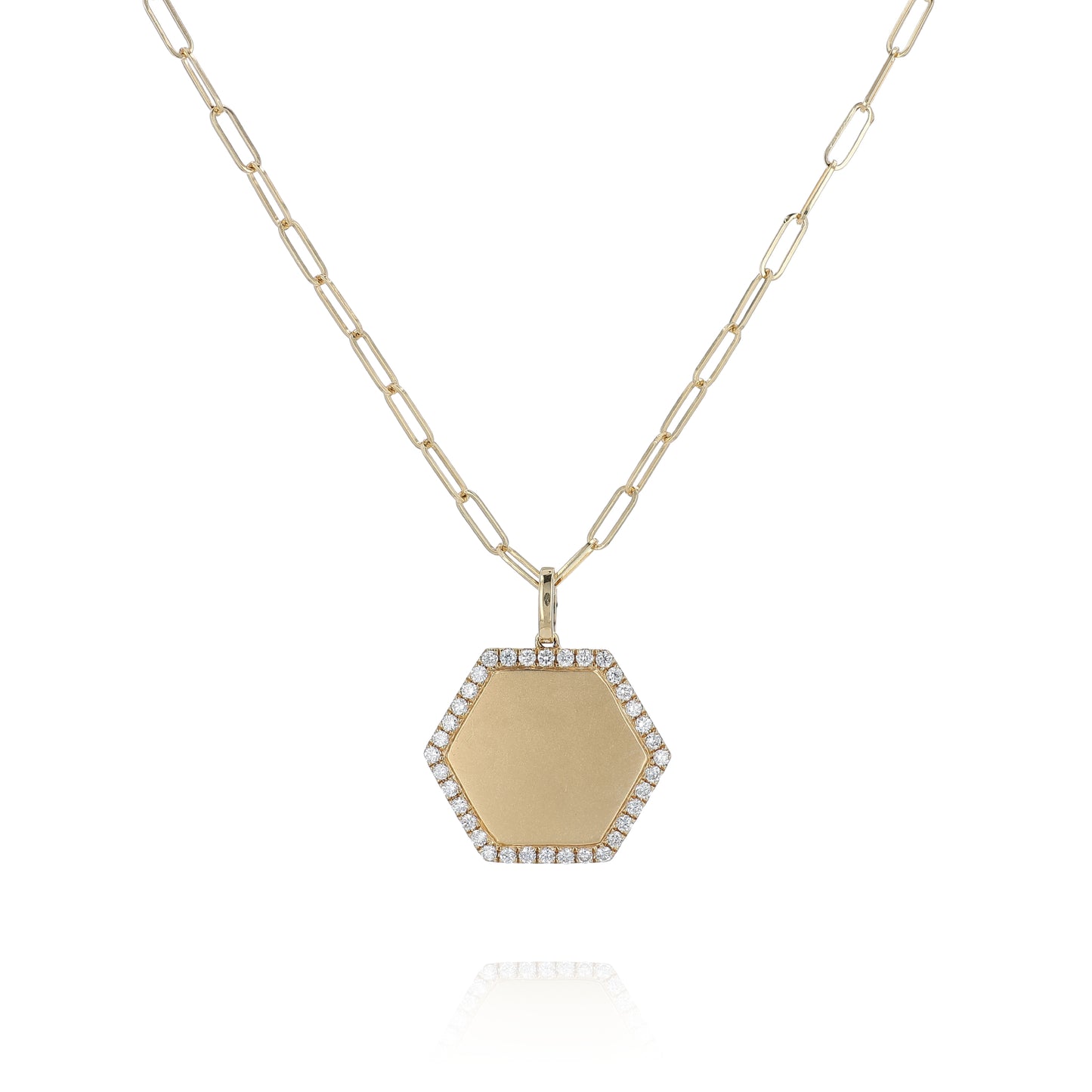 A gold hexagonal pendant necklace with a pavé diamond border and a paperclip chain, shown on a white background with a subtle reflection.