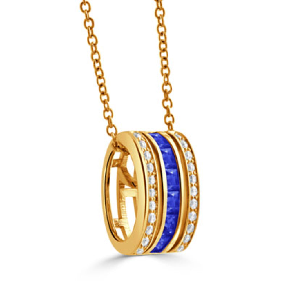 A gold pendant necklace featuring a horizontal band with a central channel of deep blue sapphires, flanked by rows of small clear stones, shown on a white background.