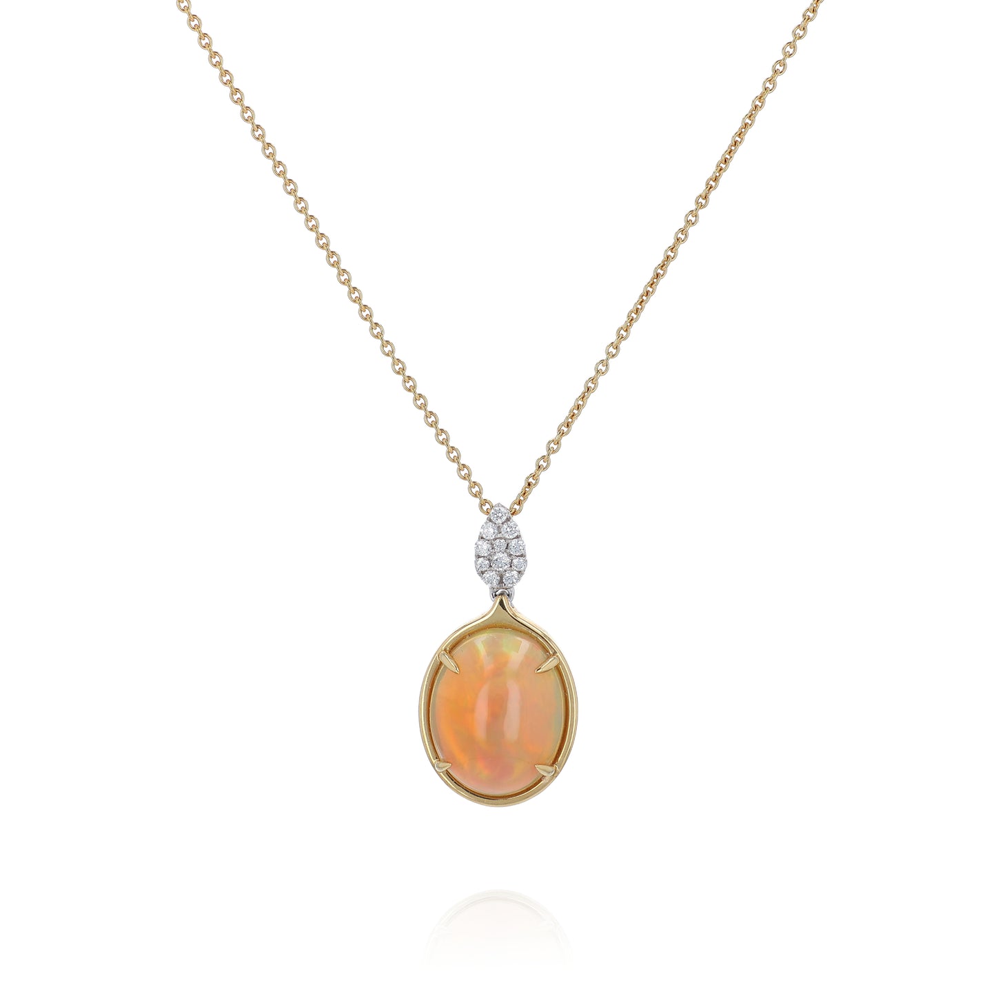 Yellow gold oval cabochon opal and diamond pendant necklace on a white background