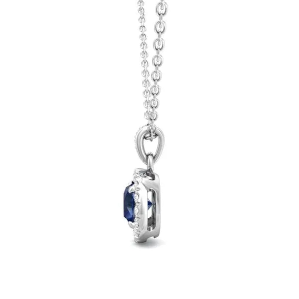 White gold necklace with a round blue sapphire center and surrounding diamond halo on a white background