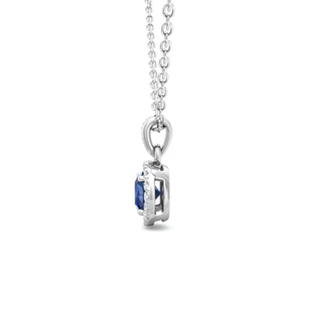 White gold necklace with a round blue sapphire center and surrounding diamond halo on a white background