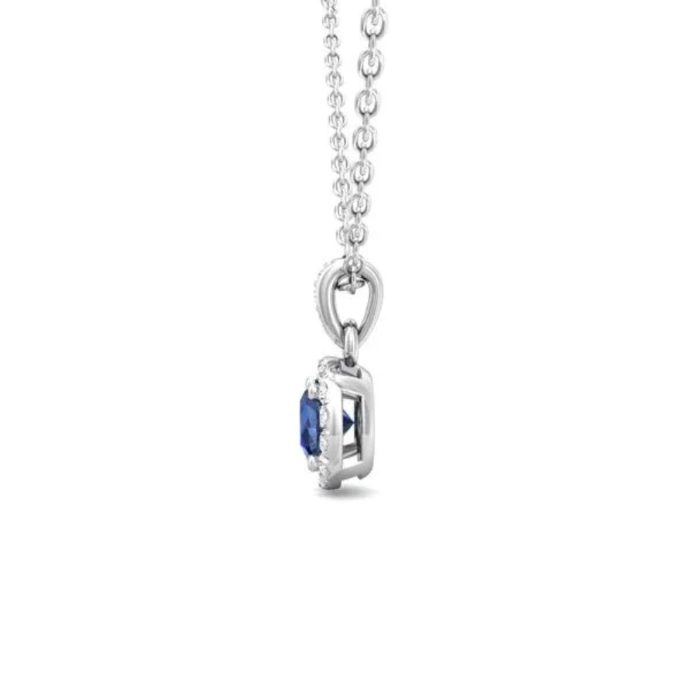 White gold necklace with a round blue sapphire center and surrounding diamond halo on a white background