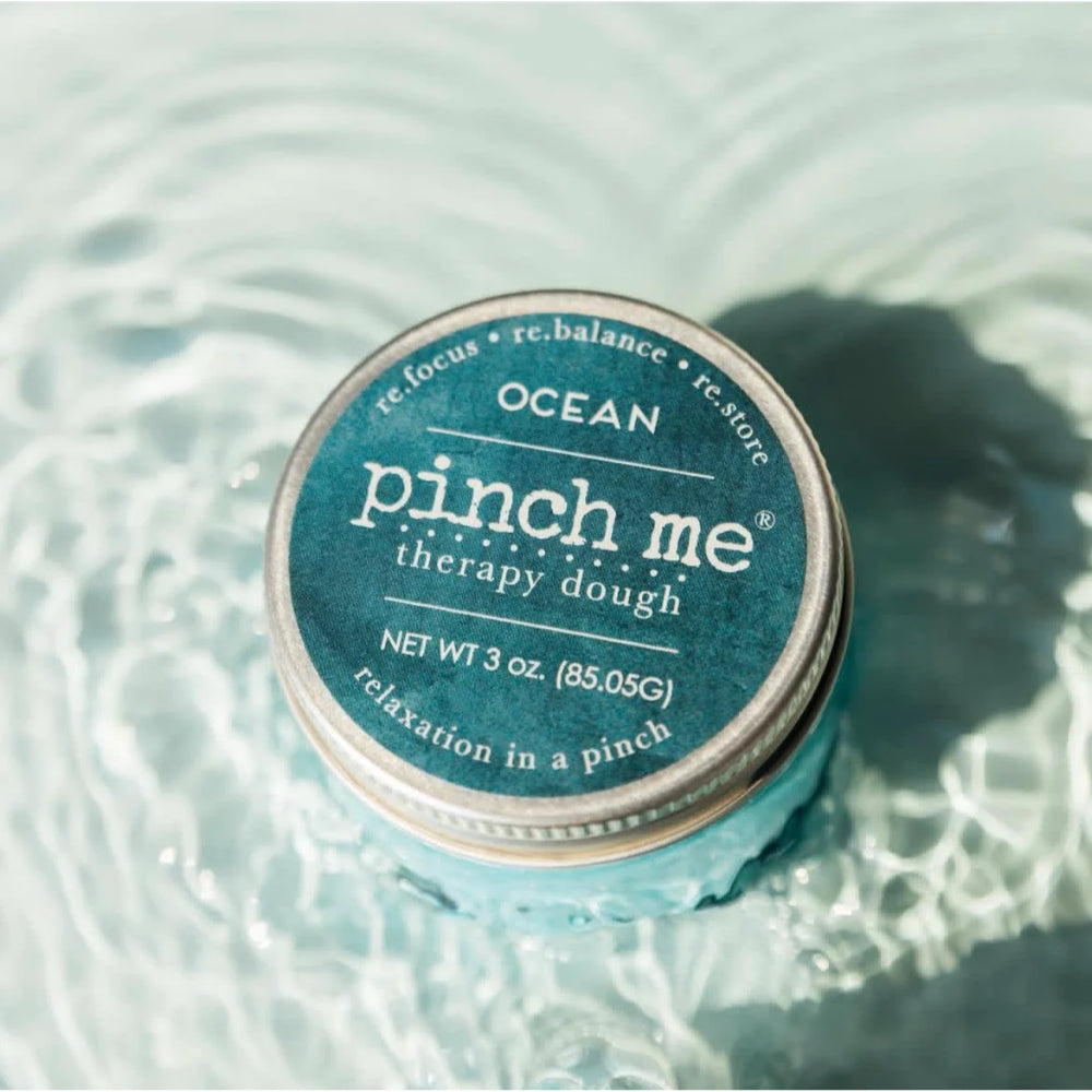 Pinch me therapy dough container labeled 'Ocean' on a water background.