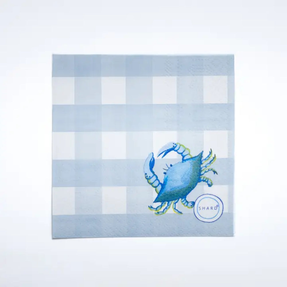 A cocktail napkin with a blue crab on a white background 