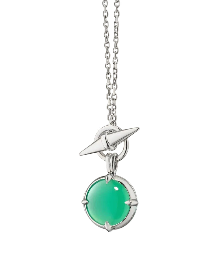 A silver chain necklace featuring a unique toggle clasp and a dangling circular pendant with a vibrant green cabochon stone, set against a solid off-white background.