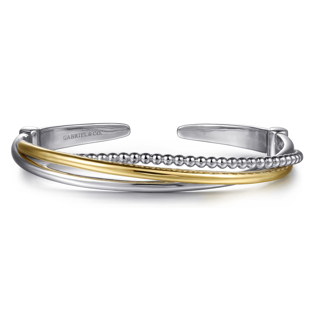 Silver and gold bangle on a white background