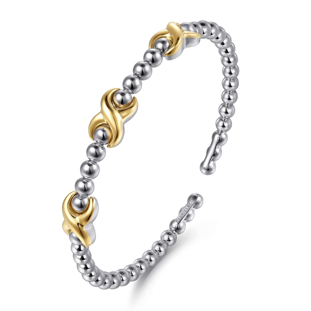 Silver and gold bracelet on a white background