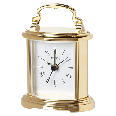 A gold-finished Seiko table clock with a white face, black Roman numeral hour markers, and a top handle, shown on a plain white background.
