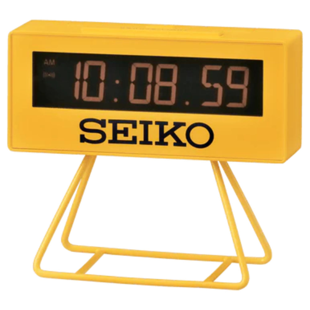 A bright yellow Seiko digital alarm clock with a wire stand, featuring a black display screen showing the time 10:08.59 and the brand name 'SEIKO' printed in black on the front.
