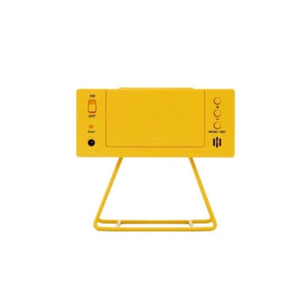 A bright yellow electronic device with a matching yellow stand, featuring a power switch on the left and control buttons on the right, set against a plain white background.