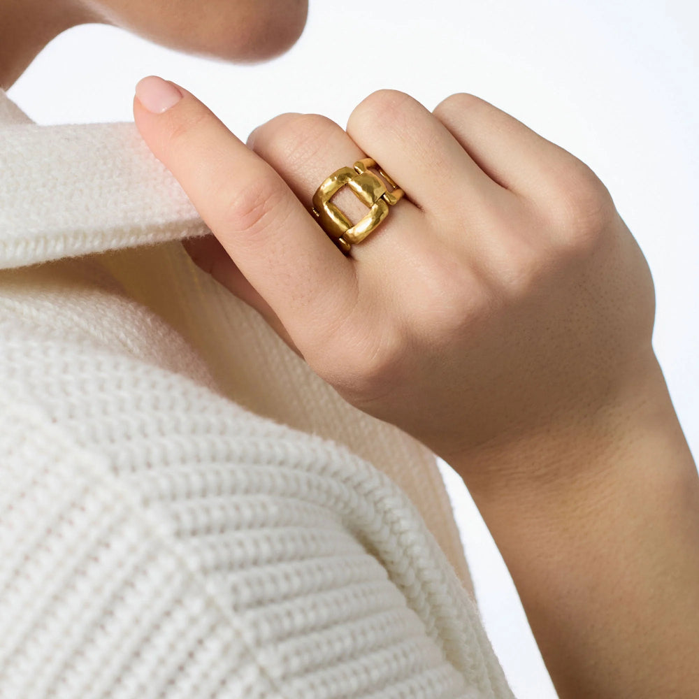 Hand wearing a gold ring on a white background