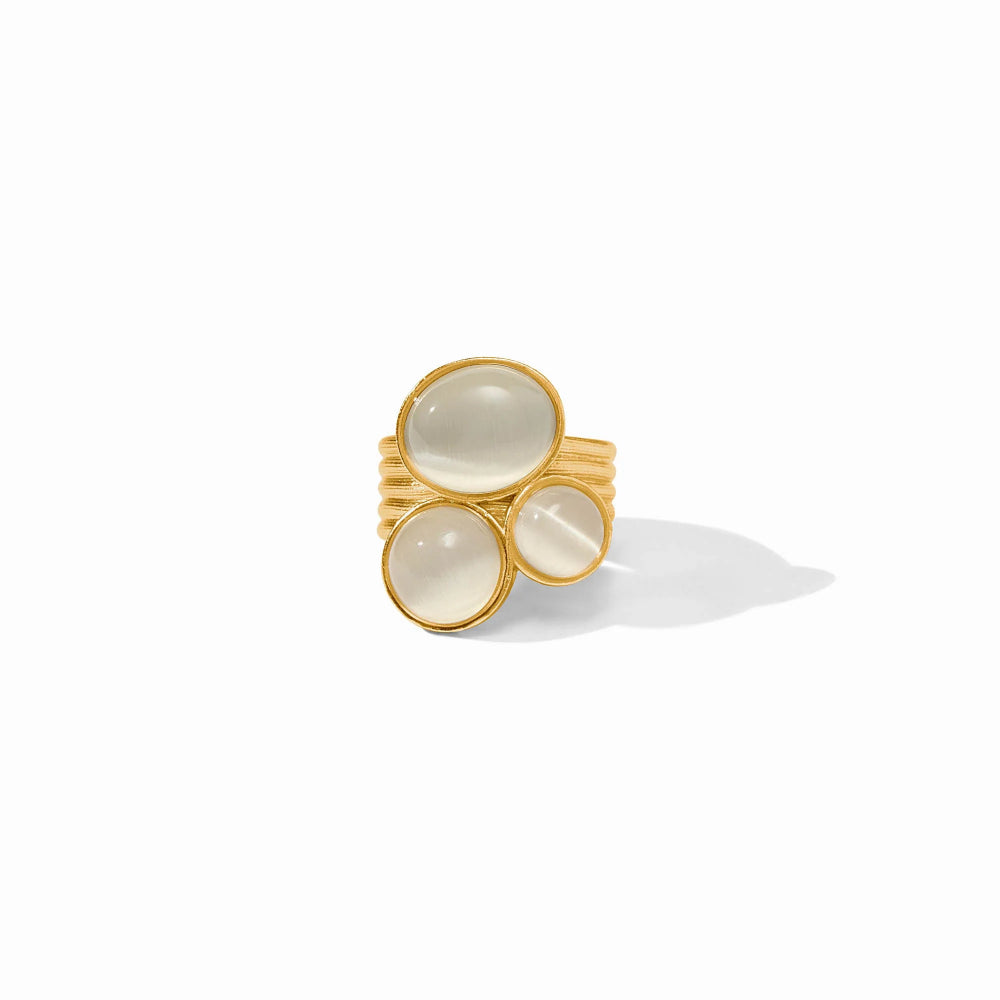 A gold ring featuring three oval cabochon gemstones in different sizes, set against a clean white background with a soft shadow.