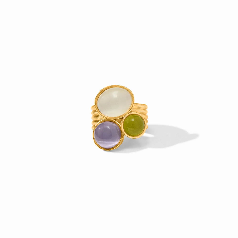 Gold ring with three colored gemstones on a white background