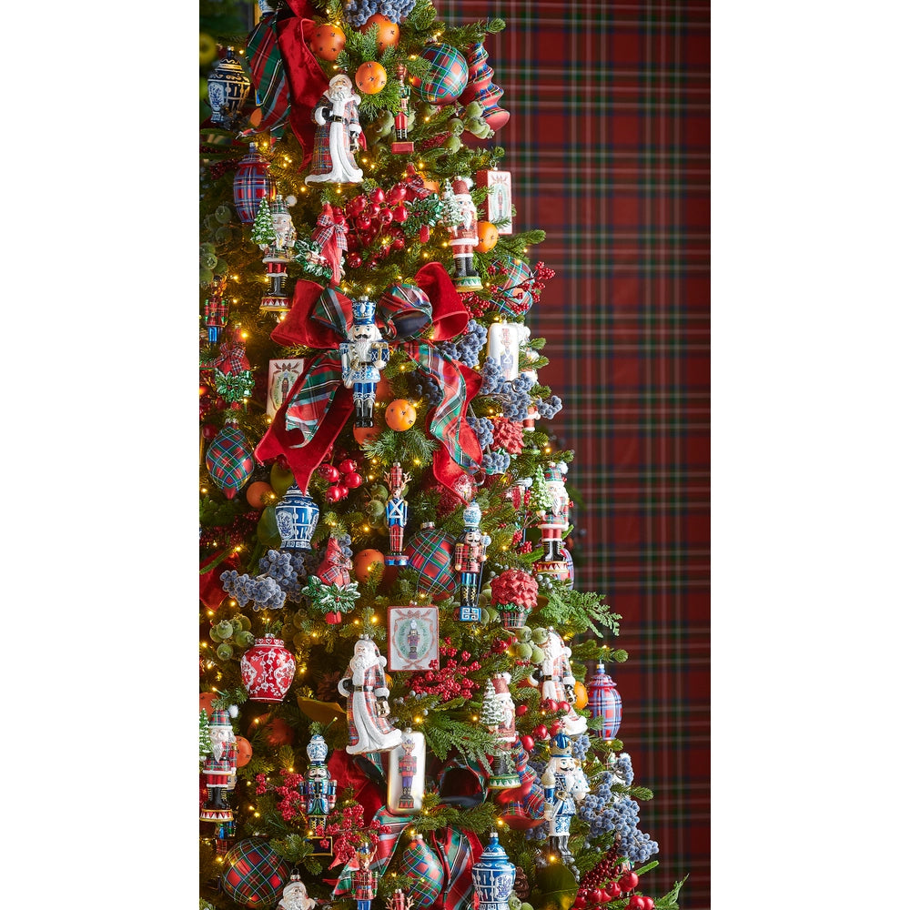 Decorated Christmas tree with ornaments against a plaid background