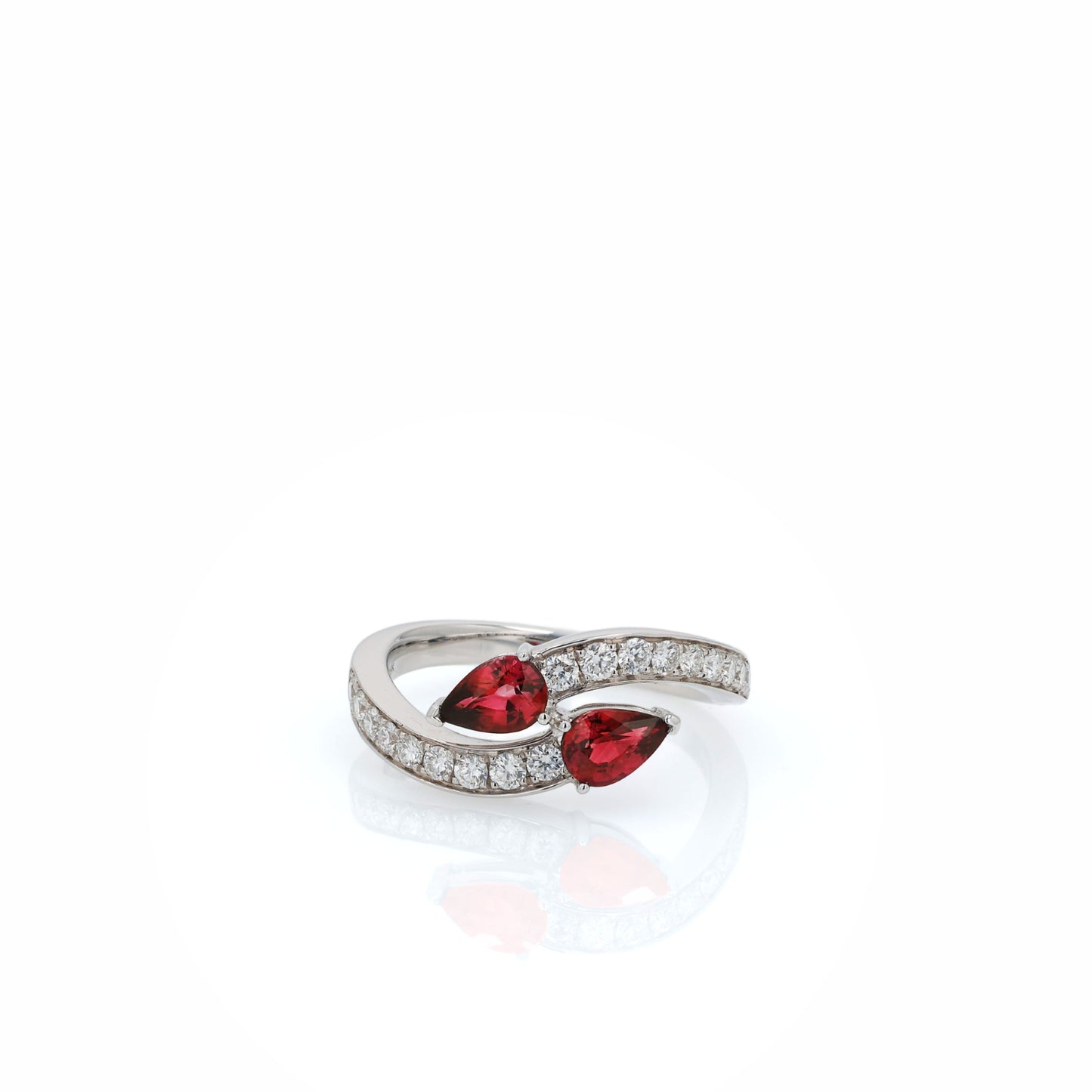 White gold diamond ring with pear shaped rubies on a white background