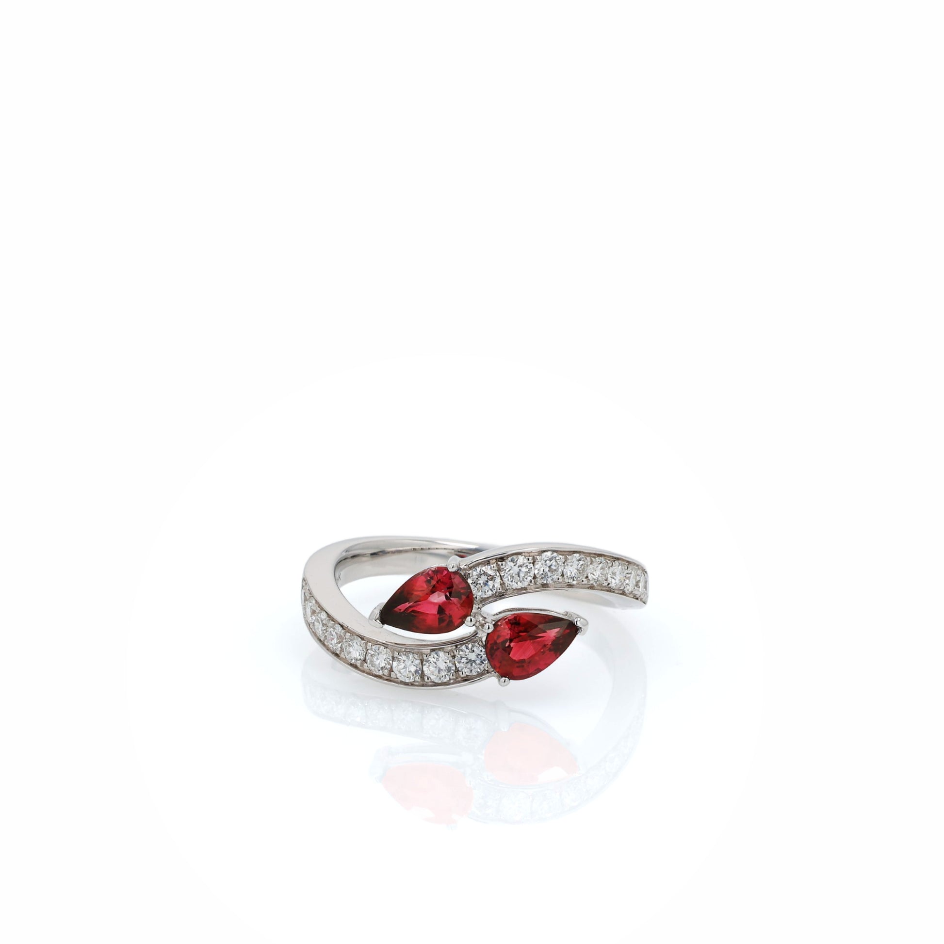 White gold diamond ring with pear shaped rubies on a white background