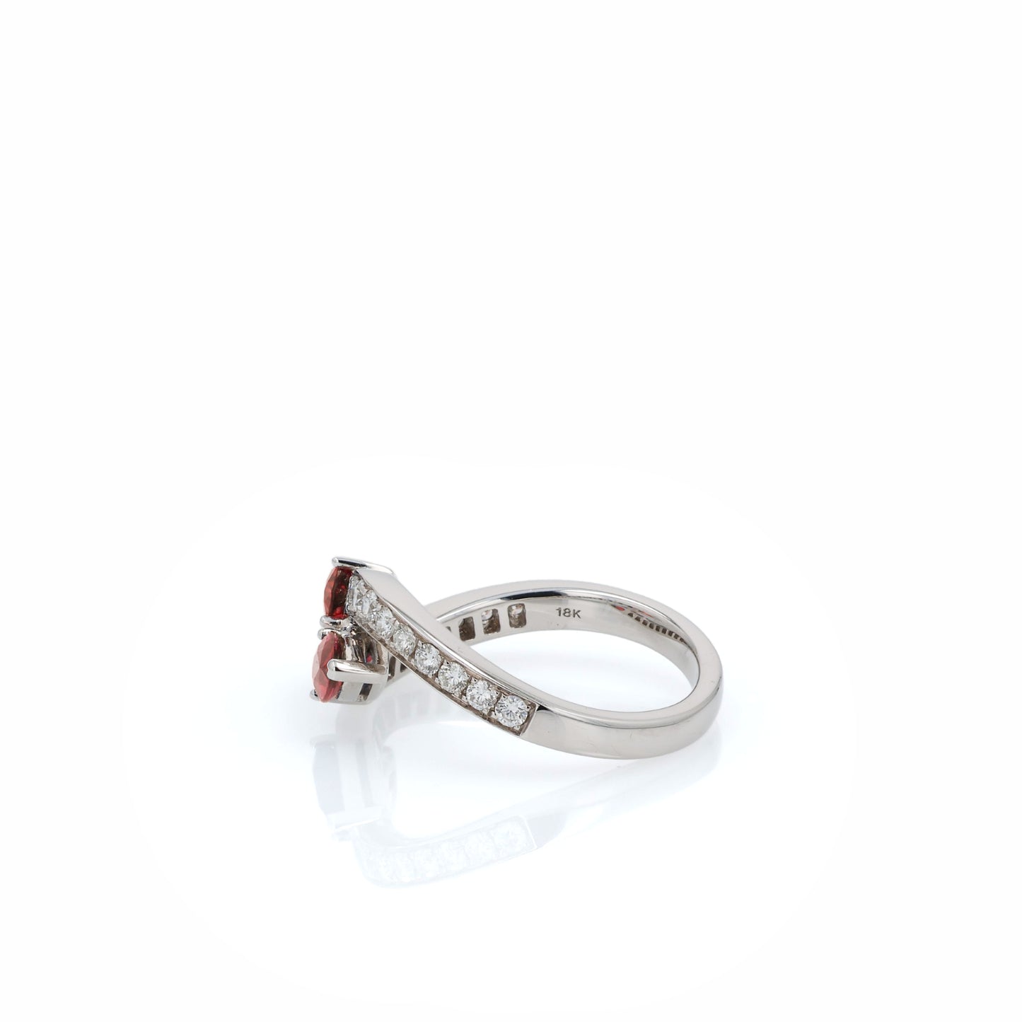 White gold diamond ring with pear shaped rubies on a white background