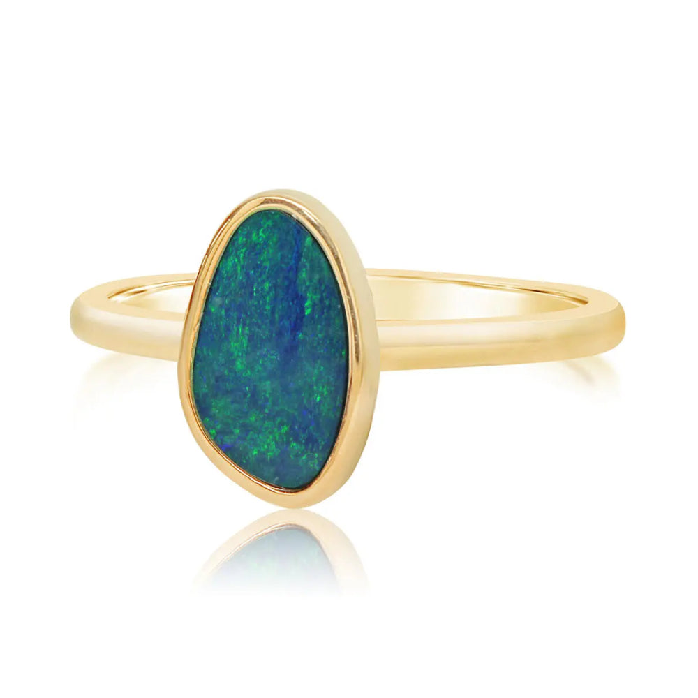 Gold ring with a green opal stone on a white background