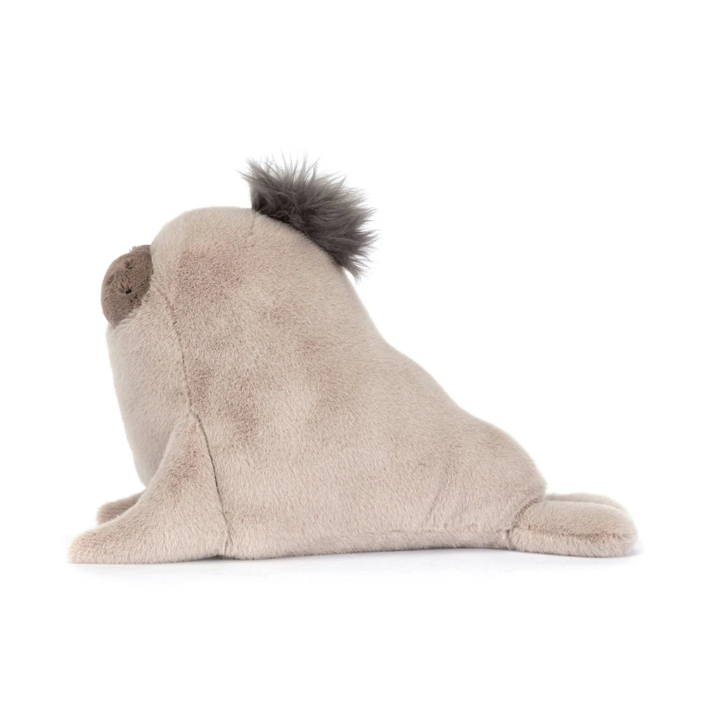A side photo of a  beige sea lion plush toy on a white backround.