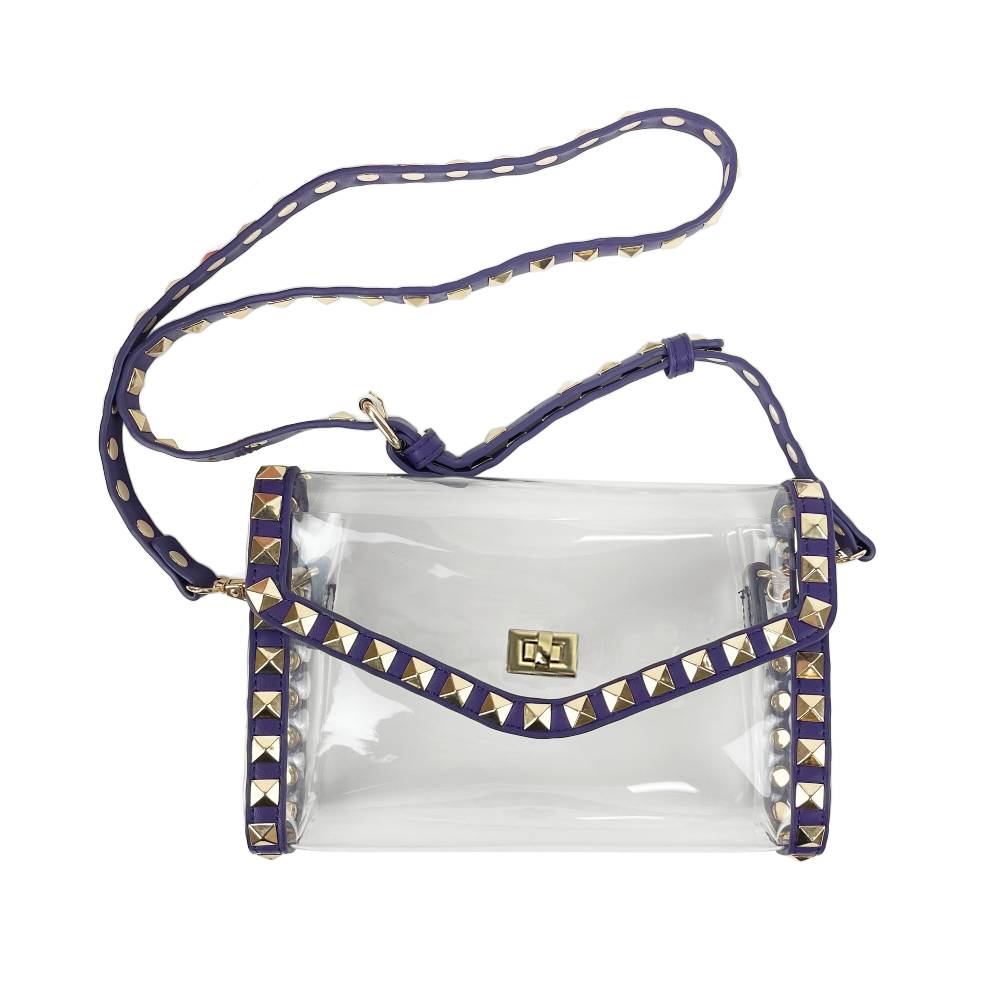 A clear plastic crossbody bag with a purple strap and trim adorned with gold pyramid studs, featuring a gold-tone logo on the front flap.