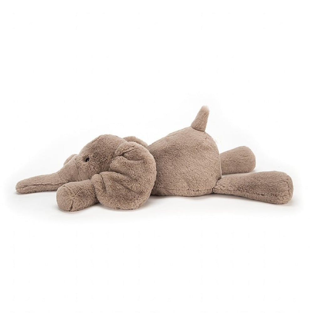 A side photo of a medium size plush toy elephant with soft grey-brown fur, big black eyes, and large ears on a white backround 