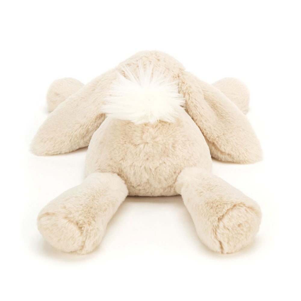 Photo of the back of a medium size beige plush bunny toy on a white background.
