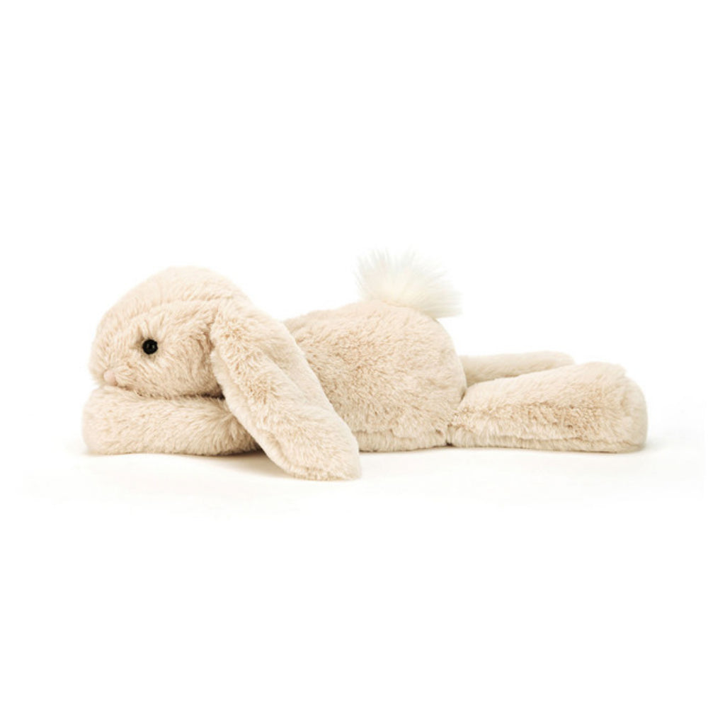 Side photo of a medium size beige plush bunny toy on a white background.